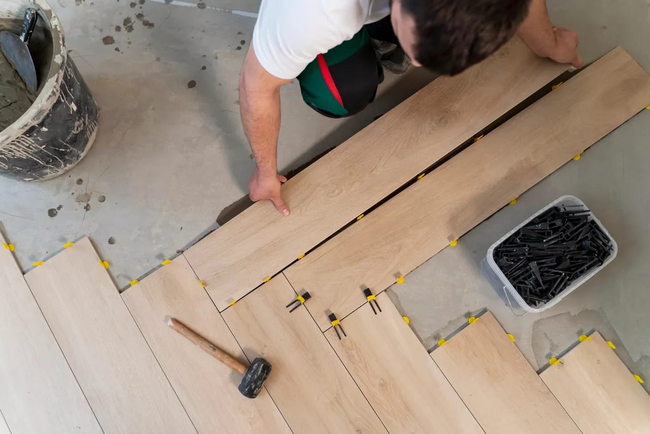 man installing wood-look tile in a bathroom