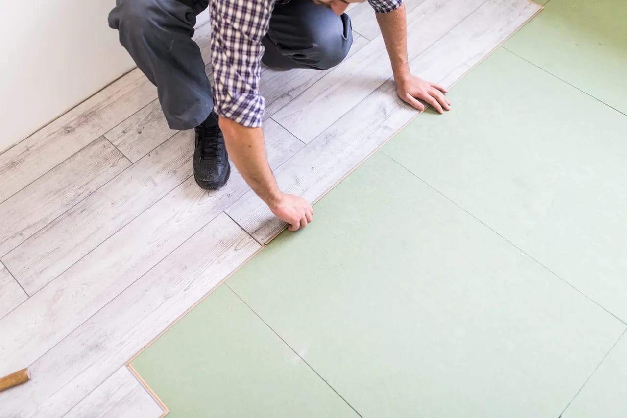 Man installing laminate flooring in condo