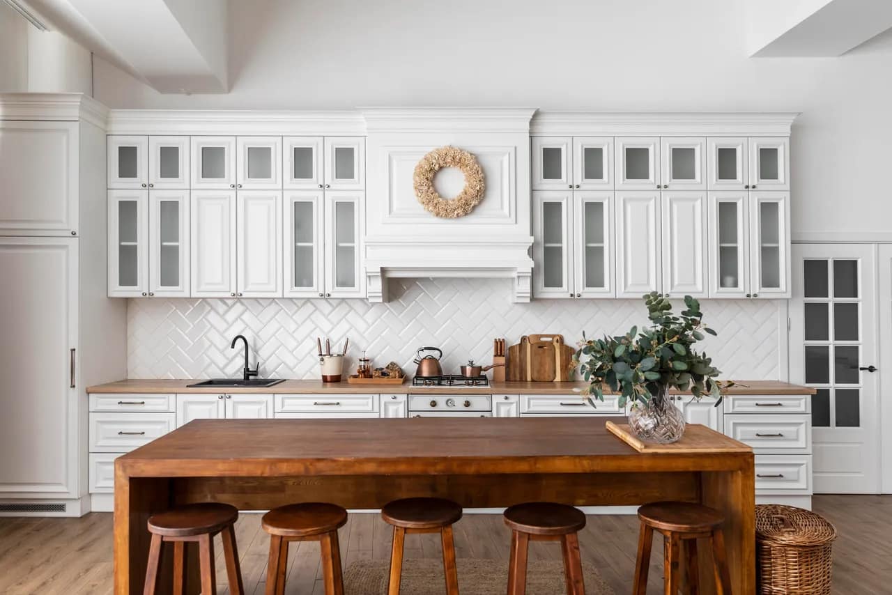 White kitchen cabinets with wood island in a large kitchen