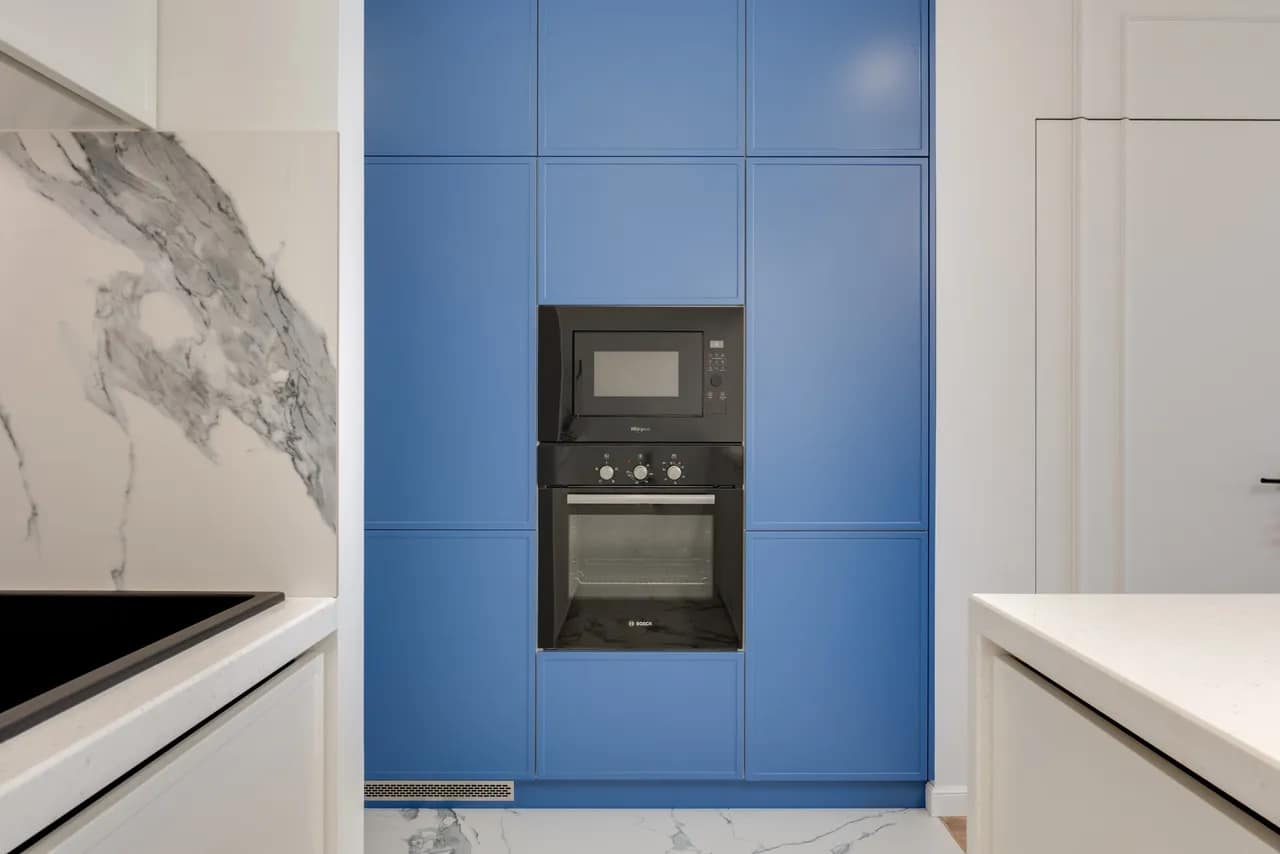 blue kitchen cabinets with built-in wall oven