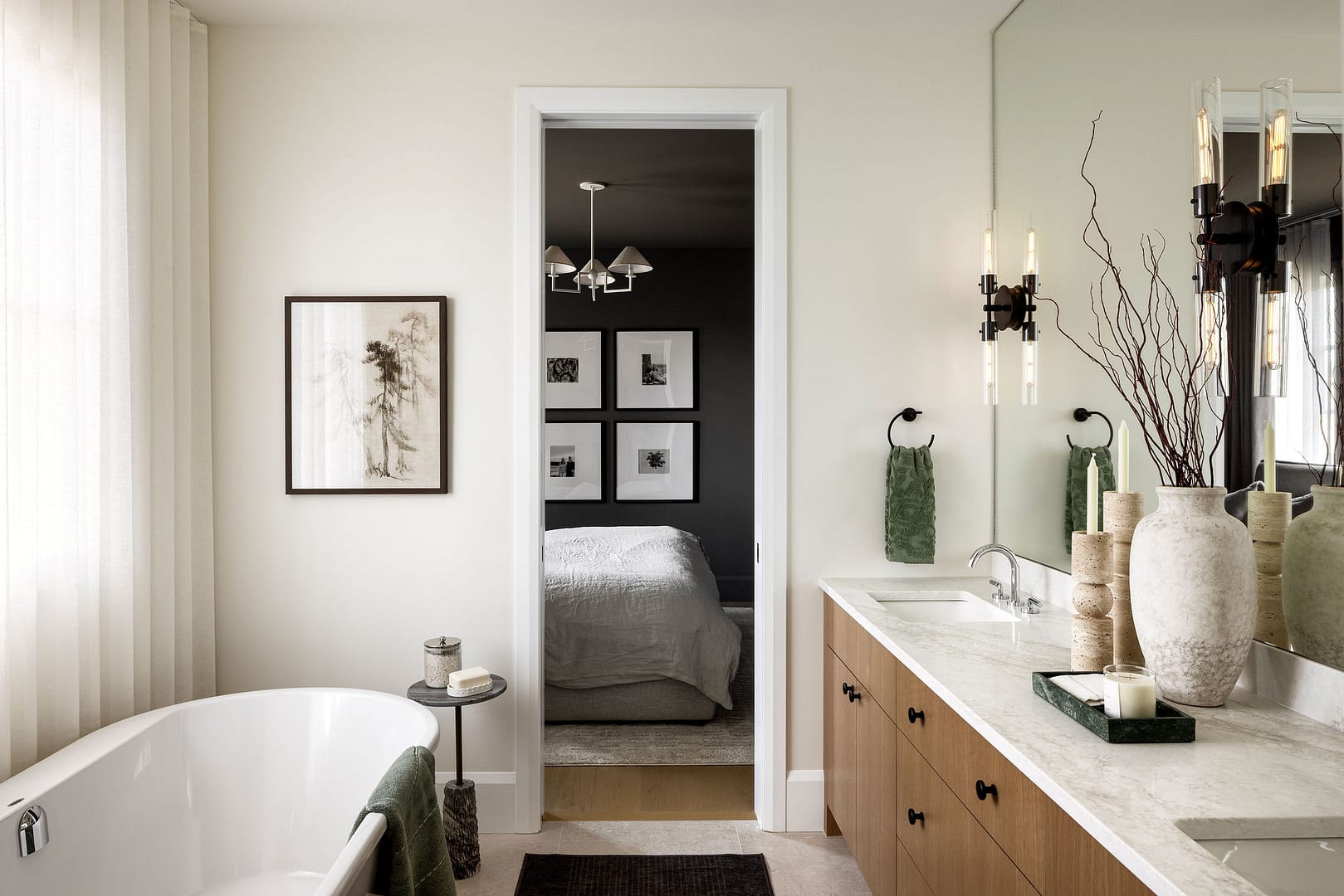 A primary suite bathroom renovation in Maple Ridge by Quay Construction featuring a white freestanding soaker tub, custom oak double vanity, and a view into a modern bedroom.