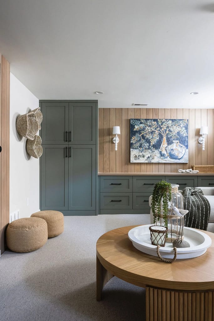 Modern basement bathroom renovation by Quay Construction featuring a glass walk-in shower, marble-style tiling, and a black vanity.