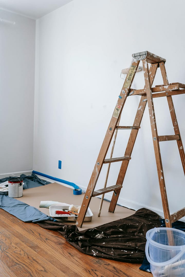 A professional painting setup with a wooden ladder and supplies for a kitchen renovation Vancouver by QUAY Construction.