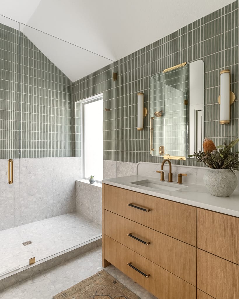 Modern primary bathroom featuring sage green kit-kat tiles and a light wood vanity from a professional home renovation in Terra Nova by Quay Construction.