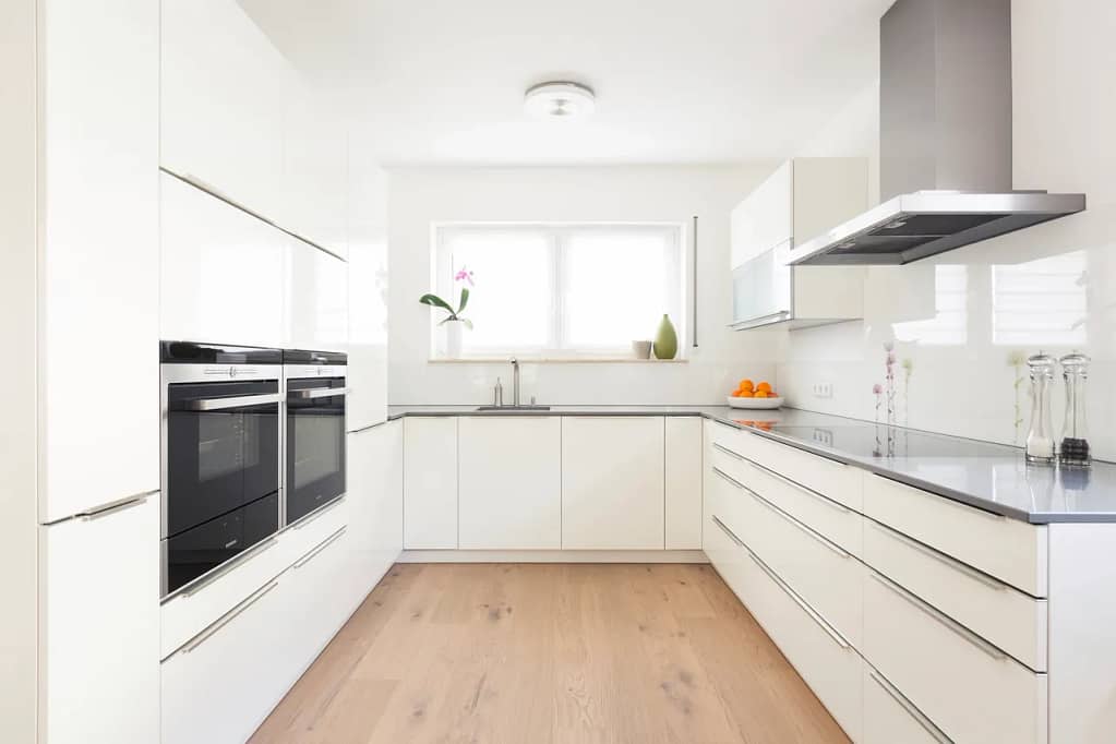 White kitchen cabinets with oak engineered hardwood flooring