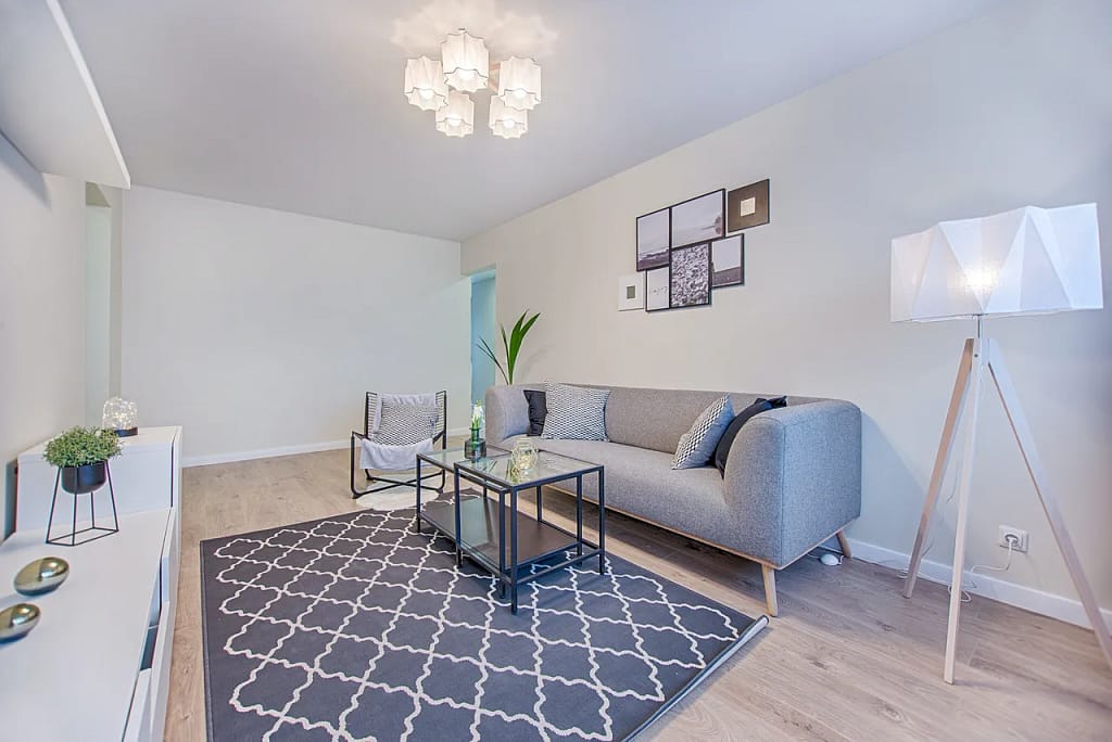 Modern finished basement renovation in Vancouver with grey flooring and recessed lighting