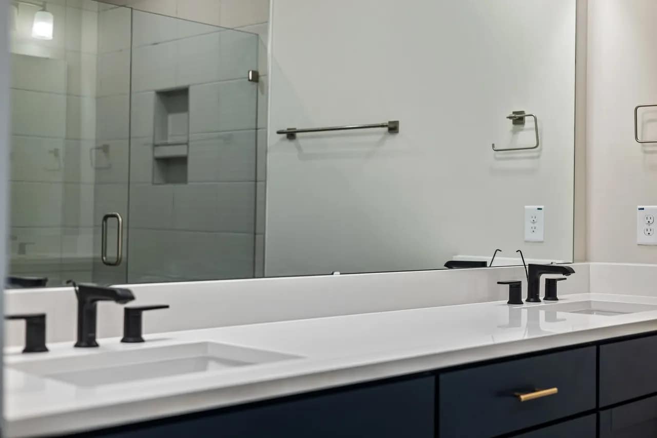 Modern bathroom with blue vanity and black faucets