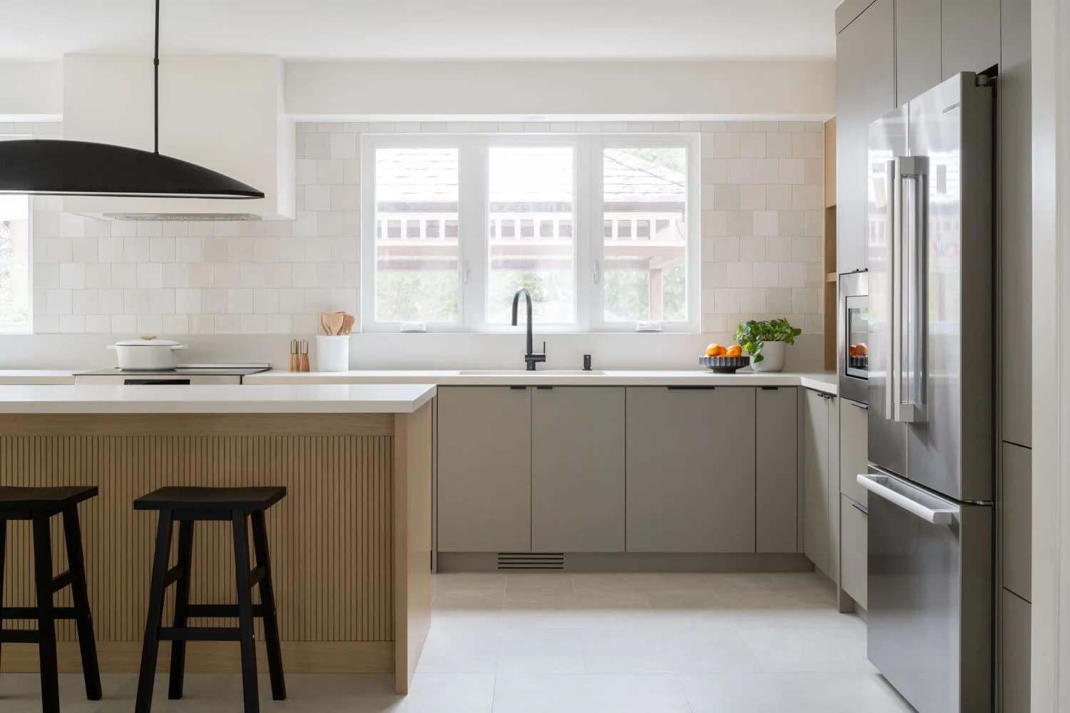 Contemporary kitchen remodel in Brighouse featuring a fluted wood island and sleek grey cabinetry by Quay Construction.