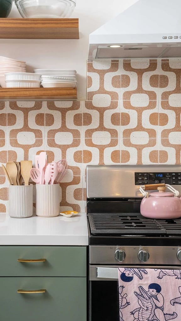 Unique retro-style kitchen renovation in Coquitlam featuring green cabinets, brass hardware, and a bold patterned backsplash over a new range, illustrating a project requiring full permits.