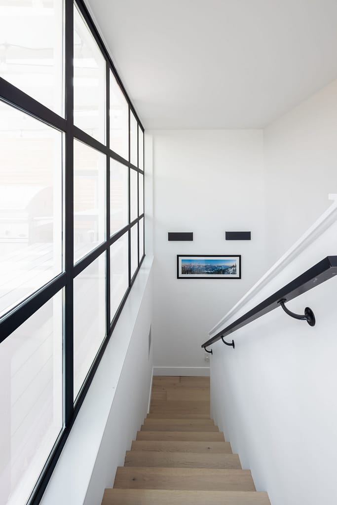 staircase with oak engineered hardwood flooring and black railings