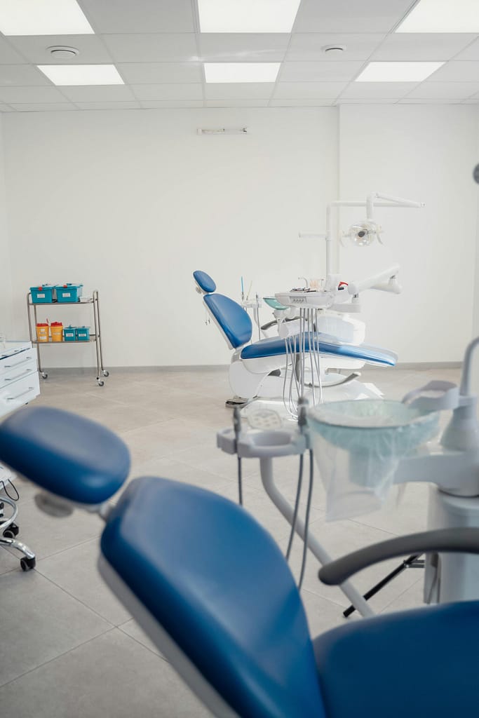 Clean and sterile dental clinic featuring modern equipment and blue chairs.