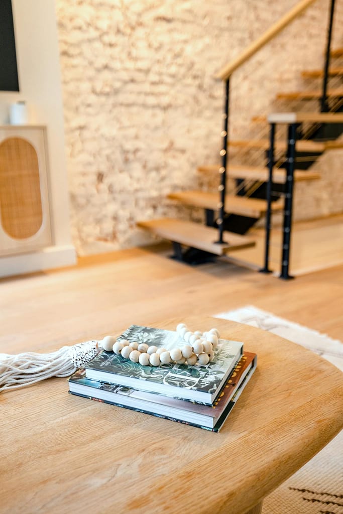 Luxury Austin Heights basement renovation with natural oak elements throughout including oak hardwood flooring, oak steps with black railings, and a media unit with rattan doors, by QUAY Construction