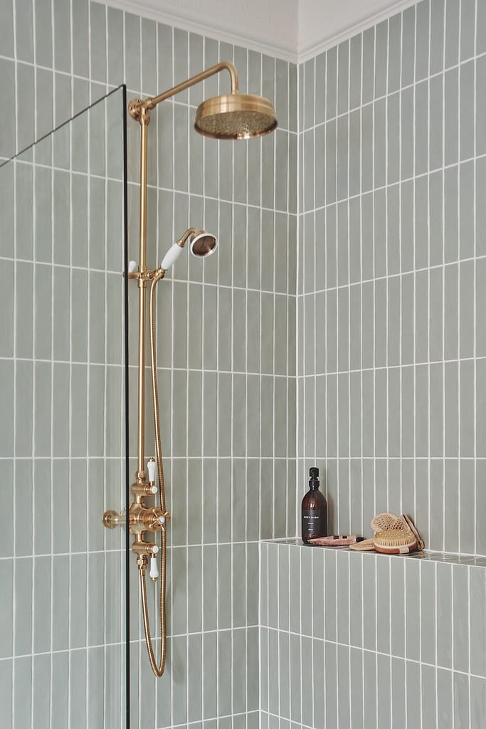 Luxury West Vancouver bathroom renovation with brass rainfall shower system and sage green vertical tile