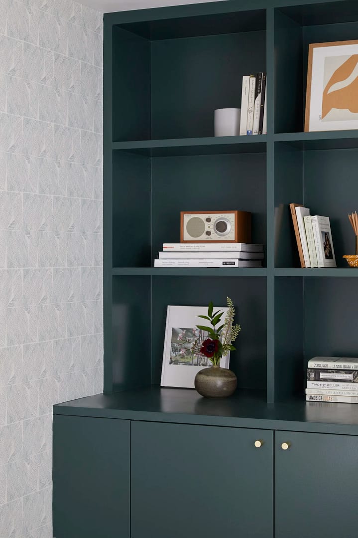 Professional basement renovation in Burnaby featuring custom dark green built-in cabinetry and integrated shelving by QUAY Construction.