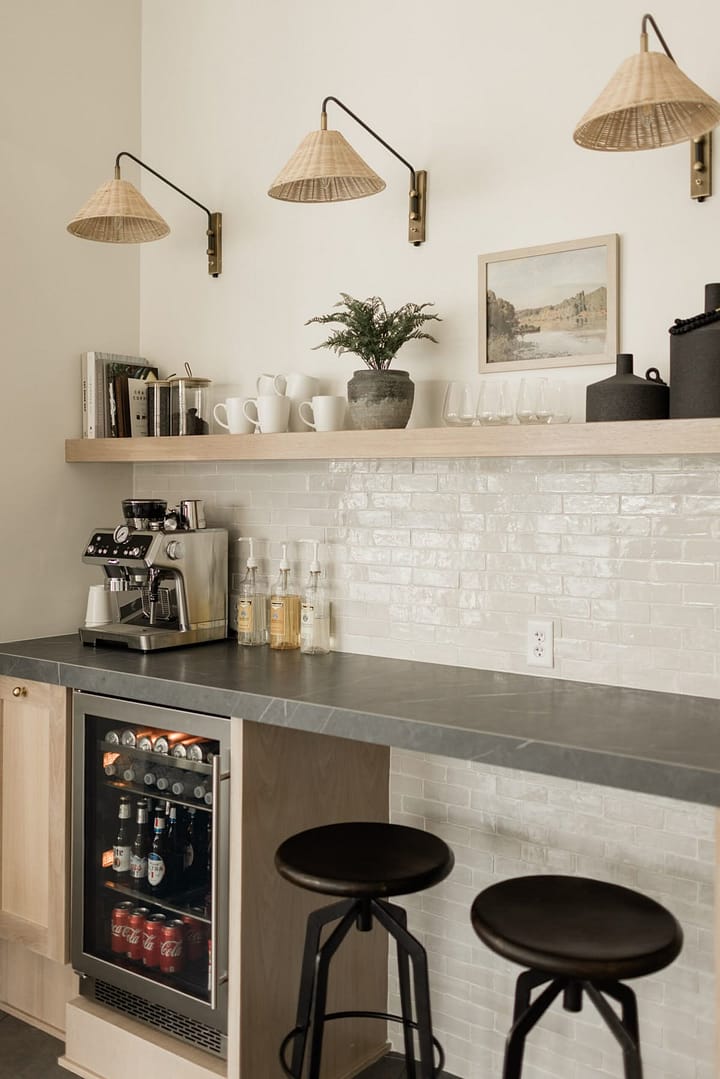 Modern basement bar with white subway tile backsplash, gray countertops, beverage fridge, and wicker pendant lights in Coquitlam renovation