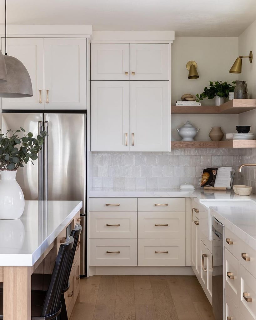 Coquitlam kitchen design featuring an L-shaped layout with white shaker cabinets, a wood island, brass hardware, and floating wood corner shelves.