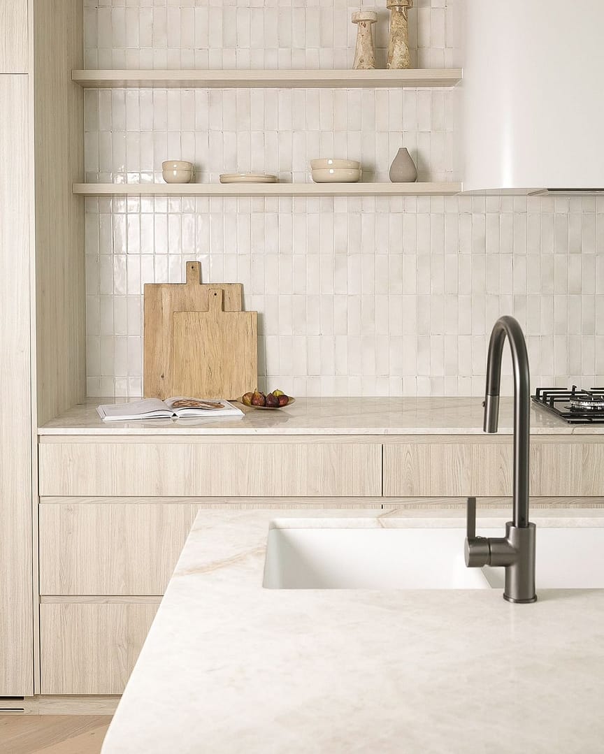 Modern Coquitlam kitchen design featuring light wood grain cabinetry, open shelving, marble countertop, and white vertical stacked subway tile backsplash.