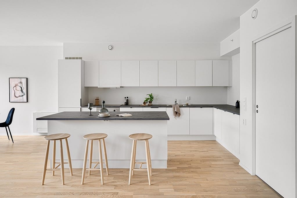 Kitchen Renovation Vancouver Featuring white cabinets and dark countertops