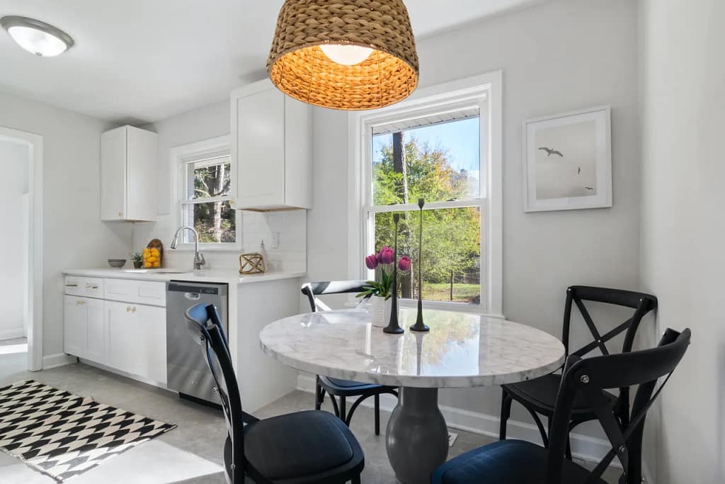 Bright kitchen, small dining table, lighting fixtures and flowers