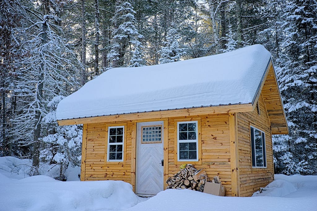 Snow-covered wooden house in the forest