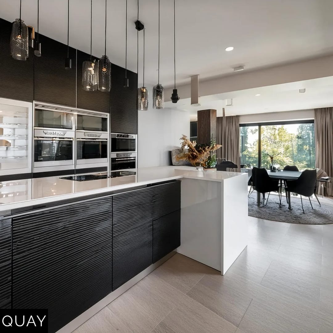 modern condo kitchen with black and white cabinets without handles and with island