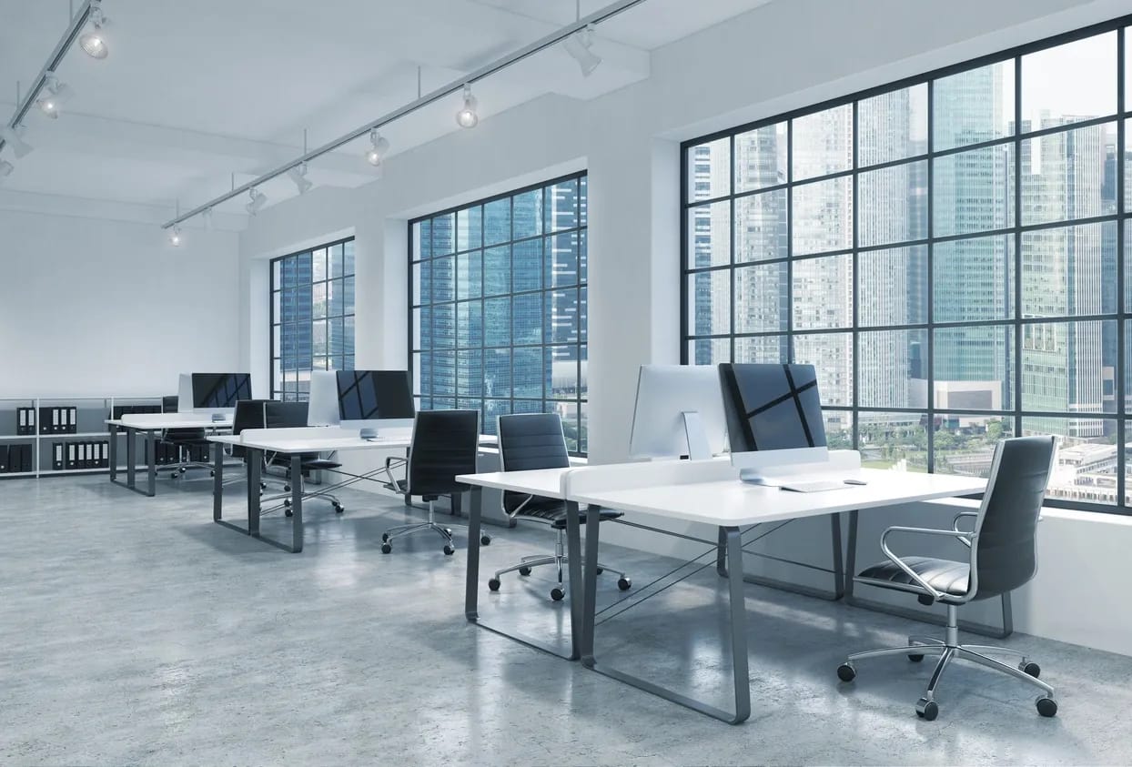 Large windows, track lighting, modern desks facing each other