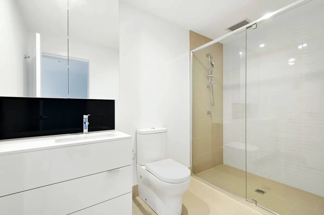 A bathroom with a clear glass shower enclosure.