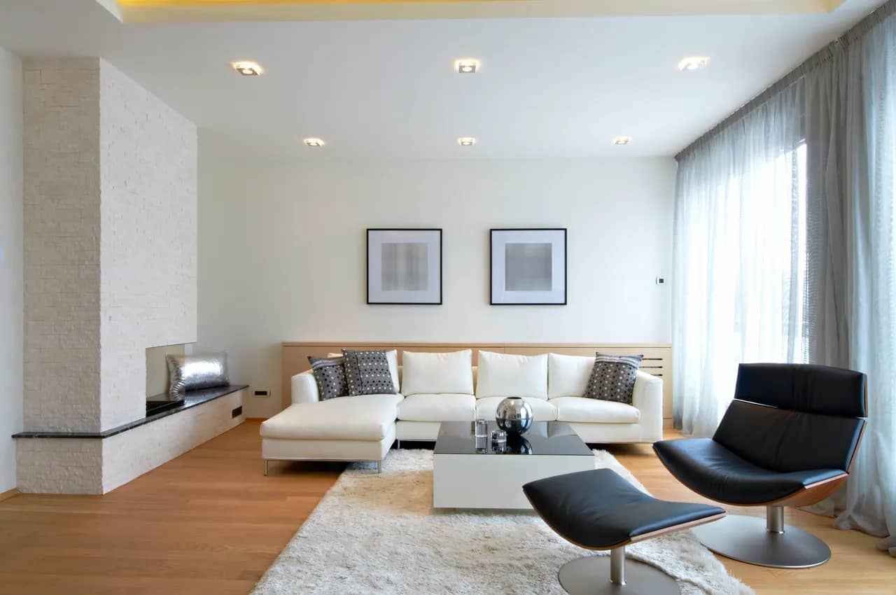 a living room with black leather chair and white couch