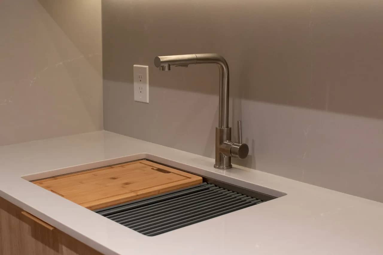 Beige countertops with stylish kitchen sink and faucet