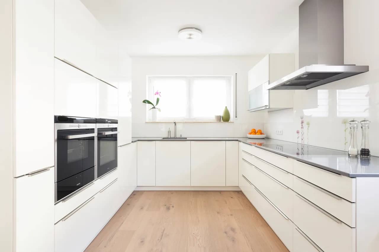 White kitchen cabinets with oak engineered hardwood flooring