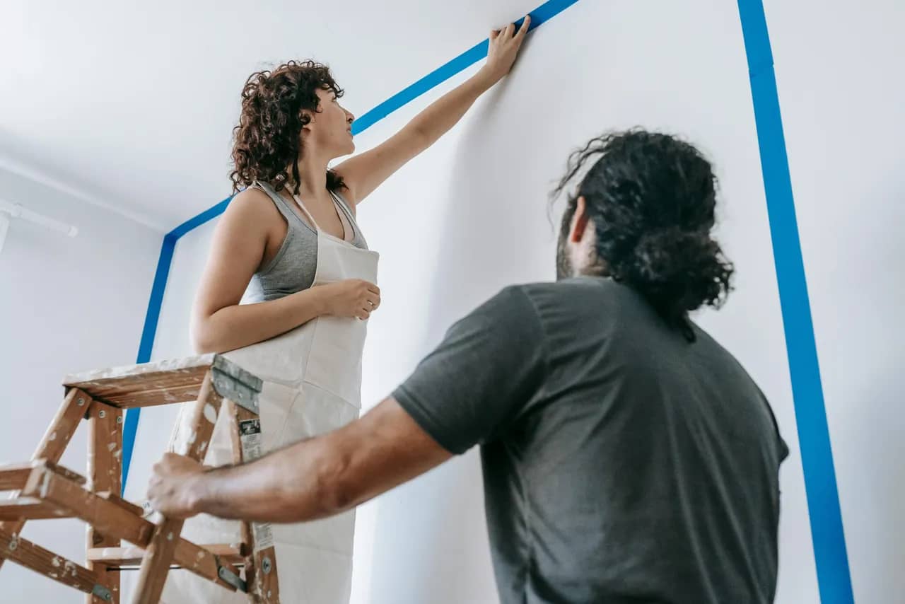 A man and woman painting their home