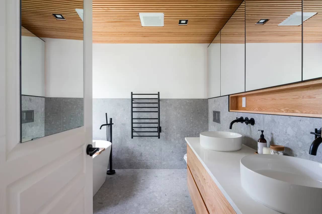 A bathroom with gray terrazzo tiles and black fixtures