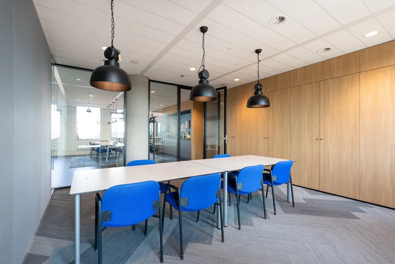 Office meeting room with blue chairs and black pendant lighting