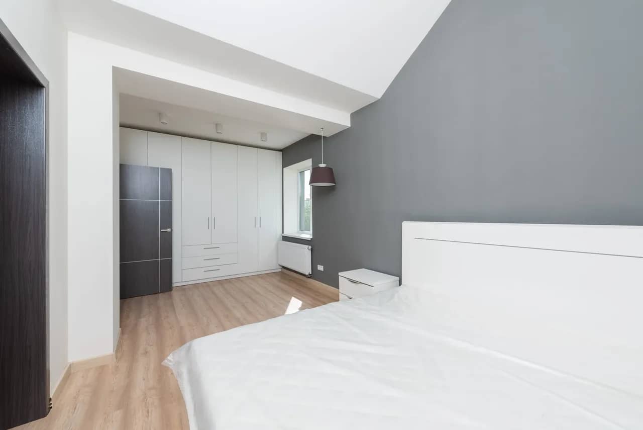 A bedroom with white built-in closets