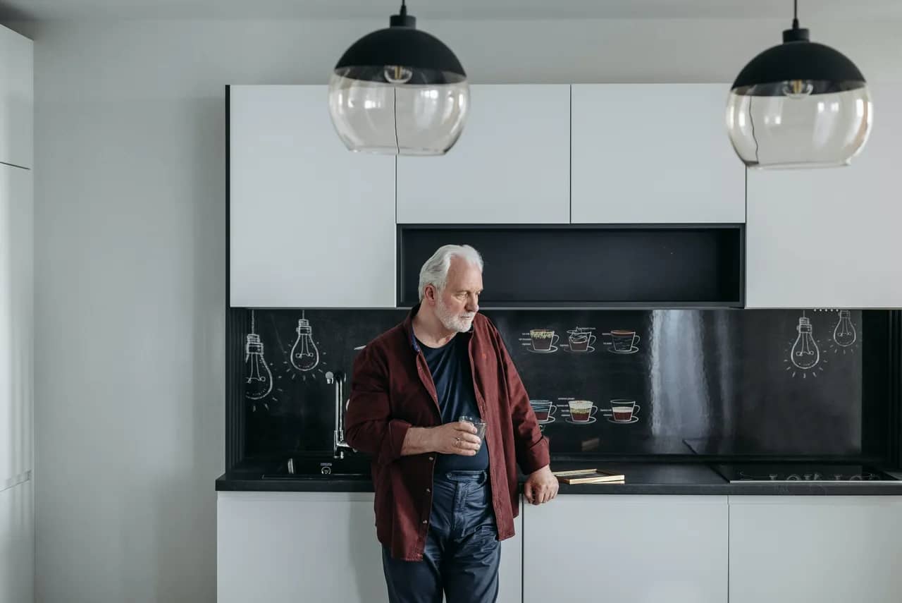 A senior man standing in the kitchen