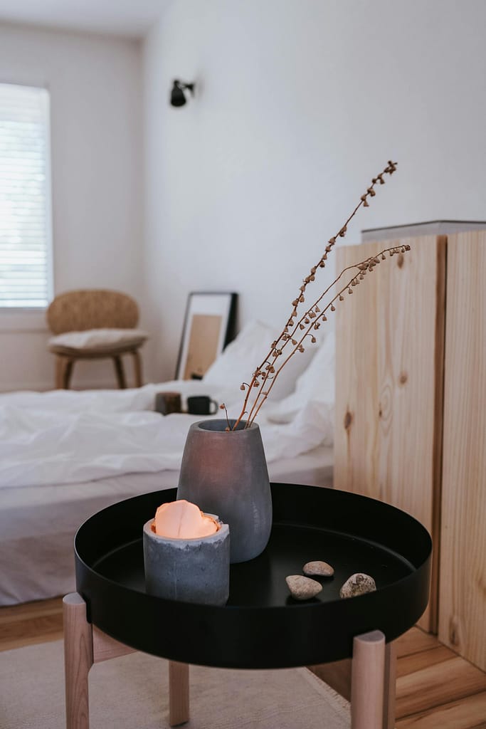 bedside table with black top and concrete vase with flower arrangement