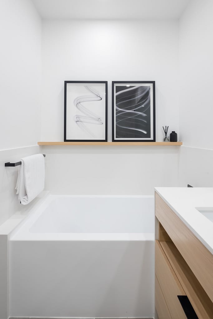 North Vancouver Bathroom Renovation featuring alcove bathtub with 2 paintings on the wall